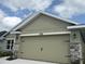 A tan two-car garage with stone accents at 4278 Sagefield Dr, St Cloud, FL 34773