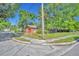 Corner lot featuring a charming single-story home with mature trees and lush landscaping at 430 S Dollins Ave, Orlando, FL 32805