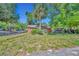 Charming single-story home on a sunny day surrounded by lush greenery and a palm tree at 430 S Dollins Ave, Orlando, FL 32805