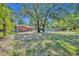 Large yard with mature trees surrounding a single-story home in a neighborhood at 430 S Dollins Ave, Orlando, FL 32805
