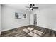Bright bedroom with ceiling fan, closet and a view to the bathroom featuring stylish wood-look flooring at 505 Lake Shore Dr, Maitland, FL 32751