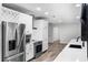 Bright kitchen featuring stainless steel appliances, white cabinets, and stylish wood-look flooring at 505 Lake Shore Dr, Maitland, FL 32751