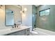 Stylish bathroom features a modern vanity, green tiled shower, and a large mirror with contemporary lighting at 532 Worthington Dr, Winter Park, FL 32789
