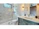 A bright bathroom features an enclosed glass shower, herringbone-patterned tiling and a vanity with great lighting at 532 Worthington Dr, Winter Park, FL 32789