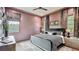 Stylish bedroom with soft rose colored walls, modern decor, including a patterned comforter and natural light at 532 Worthington Dr, Winter Park, FL 32789
