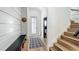 Welcoming entryway featuring horizontal shiplap accent wall, bench, bathroom, and stairway at 532 Worthington Dr, Winter Park, FL 32789