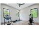 Bright exercise room with wood floors features an array of workout equipment and natural light from three windows at 532 Worthington Dr, Winter Park, FL 32789