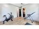 Bright exercise room features an array of equipment, wood floors, and access to another room in the house at 532 Worthington Dr, Winter Park, FL 32789