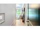 Hallway view leading to a bright bedroom with floor to ceiling glass, plush seating, and a pool view at 532 Worthington Dr, Winter Park, FL 32789