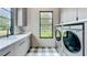 Well-equipped laundry room with modern washer/dryer, sleek cabinetry, and a sunny window at 532 Worthington Dr, Winter Park, FL 32789