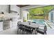 Outdoor kitchen features a built in grill, outdoor dining, and a relaxing view of the backyard pool at 532 Worthington Dr, Winter Park, FL 32789