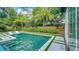 Resort-style backyard pool features lounge chairs in the water, beautiful landscaping, and an outdoor shower at 532 Worthington Dr, Winter Park, FL 32789