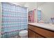 Well-lit bathroom with a single sink vanity and a shower featuring a stylish patterned curtain at 5826 Wooden Pine Dr, Orlando, FL 32829