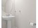 Clean powder room featuring a sleek pedestal sink, oval mirror, and modern fixtures at 5826 Wooden Pine Dr, Orlando, FL 32829