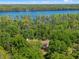Aerial view of home among trees with a lake in the background, offering privacy and natural beauty at 6037 Lake Erie Rd, Groveland, FL 34736