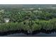 Overhead shot featuring mature trees, and water frontage with dock at 6037 Lake Erie Rd, Groveland, FL 34736