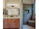 Modern bathroom features double sinks, wood cabinets, and a luxurious walk-in shower with stone accent wall at 6037 Lake Erie Rd, Groveland, FL 34736