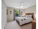 Serene bedroom with a large window, a ceiling fan, and ample closet space, creating a restful retreat at 6037 Lake Erie Rd, Groveland, FL 34736