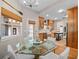 Bright dining area with glass-top table and access to the kitchen featuring wooden cabinetry at 6037 Lake Erie Rd, Groveland, FL 34736