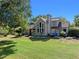 Rear exterior view of the home featuring a tall chimney, screened porch and well maintained yard at 6037 Lake Erie Rd, Groveland, FL 34736