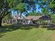 Beautiful home exterior with a spacious lawn, porch, and covered parking area at 6037 Lake Erie Rd, Groveland, FL 34736