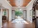 Elegant foyer with a wood-paneled ceiling, grand entrance doors, and abundant natural light at 6037 Lake Erie Rd, Groveland, FL 34736