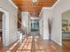 Bright foyer featuring hardwood floors, a wood-paneled ceiling, and staircase with iron railings at 6037 Lake Erie Rd, Groveland, FL 34736