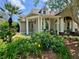Inviting home exterior with a porch, rocking chairs, and lush landscaping under a blue sky at 6037 Lake Erie Rd, Groveland, FL 34736