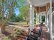 Spacious front porch featuring rocking chairs, brick accents, and views of a well-manicured lawn at 6037 Lake Erie Rd, Groveland, FL 34736
