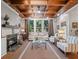 Bright living room featuring a fireplace, coffered wood ceiling, and large windows overlooking outdoor views at 6037 Lake Erie Rd, Groveland, FL 34736