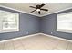 Empty bedroom featuring neutral paint, two windows for natural light, and tile flooring at 607 Brittany Ct, Casselberry, FL 32707