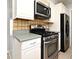 Kitchen boasting stainless steel appliances, tiled backsplash, and ample countertop space at 607 Brittany Ct, Casselberry, FL 32707