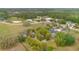 Aerial view of the property in a lush, wooded setting near neighboring houses and open fields at 6816 Greengrove Blvd, Clermont, FL 34714