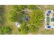 Bird's eye view of the property featuring outdoor lounging areas, a pond, and verdant foliage at 6816 Greengrove Blvd, Clermont, FL 34714