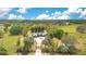 Expansive aerial view showcasing the house, driveway, and surrounding lush greenery and mature trees at 6816 Greengrove Blvd, Clermont, FL 34714