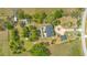 Overhead view showcases the house, pool area, and landscaped yard with mature trees and plantings at 6816 Greengrove Blvd, Clermont, FL 34714
