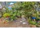 Lush backyard garden with stone pathway, mature trees, and a tranquil setting at 6816 Greengrove Blvd, Clermont, FL 34714