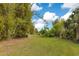 Expansive backyard surrounded by mature trees offering privacy and a serene setting for outdoor activities at 6816 Greengrove Blvd, Clermont, FL 34714