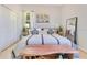 Calm bedroom design featuring a queen bed with decorative pillows, side tables, and a full length mirror at 6816 Greengrove Blvd, Clermont, FL 34714