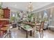 Dining room featuring a long wooden table, bright windows, and decorative shelving at 6816 Greengrove Blvd, Clermont, FL 34714