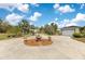 Long driveway leading to a spacious home and detached garage, surrounded by lush greenery and palm trees at 6816 Greengrove Blvd, Clermont, FL 34714