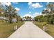 Long driveway leading up to a house with beautiful landscaping and greenery at 6816 Greengrove Blvd, Clermont, FL 34714