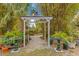 Enchanting garden arbor entrance framed by mature bamboo, leading to a serene backyard retreat at 6816 Greengrove Blvd, Clermont, FL 34714