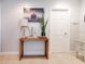 Hallway featuring art, a side table, and a paneled white door at 6816 Greengrove Blvd, Clermont, FL 34714
