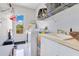 Bright laundry room featuring a white washer and dryer, storage shelves, and natural light from an exterior door at 6816 Greengrove Blvd, Clermont, FL 34714