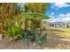 Charming outdoor seating area with an umbrella and lush greenery creating a peaceful garden retreat at 6816 Greengrove Blvd, Clermont, FL 34714