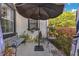 Outdoor patio with seating area, black umbrella, manicured hedges, and black trimmed windows at 6816 Greengrove Blvd, Clermont, FL 34714