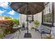 Outdoor patio with seating area, black umbrella, manicured hedges, and black trimmed windows at 6816 Greengrove Blvd, Clermont, FL 34714