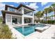 This backyard showcases a sparkling pool, spa, covered patio, and an outdoor kitchen for entertaining guests at 7928 Jacks Club Dr, Kissimmee, FL 34747