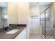 Modern bathroom featuring a glass-enclosed shower and a vanity with a dark countertop at 7928 Jacks Club Dr, Kissimmee, FL 34747